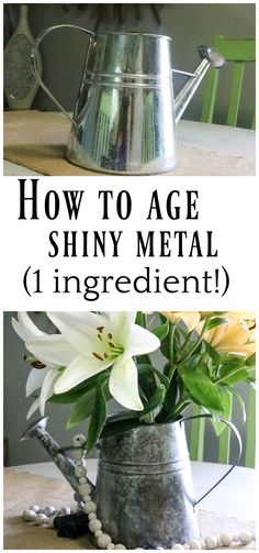 a metal watering can sitting on top of a table next to a vase filled with flowers