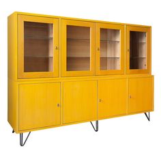 a yellow cabinet sitting on top of a tiled floor next to a wall with glass doors