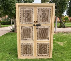 an intricately carved wooden door in the grass