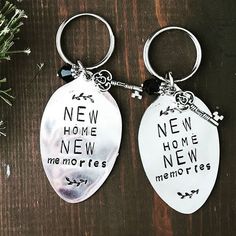 two silver key chains with new home and memories engraved on them