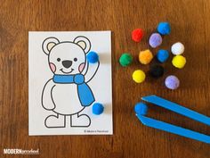 a bear coloring page with pom poms on the table next to some scissors