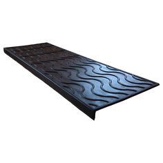 a black mat with wavy design on the top and bottom, in front of a white background