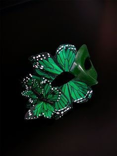 This striking handmade mask features intricate emerald green butterfly wings adorned with delicate white accents, creating a captivating whimsical look. Perfect for masquerade balls, costume parties, or any special occasion, the Emerald Butterfly Masquerade enhances your ensemble with its unique charm. Age Group/Gender - Adult/Women Size/Type - One size fits all adults Mask Color - Emerald Green Butterfly Color - Emerald Green Mask Material - polyresin Accent Material - butterflies made of feath Material Butterflies, Emerald Green Butterfly, Butterfly Masquerade, Emerald Butterfly, Kids Party Packs, Green Mask, Butterfly Mask, Handmade Mask, Ball Mask