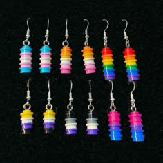 six pairs of earrings with different colors and shapes on black background, one is made out of