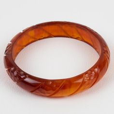 This is a lovely red tea amber Bakelite carved bracelet bangle. It features a spacer domed shape with deep geometric carving all around. The color is an intense red-amber tone with complete translucency.  Measurements: Inside across is 2.63 in diameter (6.7 cm) - outside across is 3.19 in diameter (8.1 cm) - width is 0.63 in wide (1.5 cm) - The inner circumference of the bracelet is 8.28 in (21.04 cm).  Please see the measurements noted above in the description for the best approximate dimension Bakelite Jewelry, Red Tea, Amber Bracelet, Bracelet Bangle, Color Therapy, Cute Jewelry, Aesthetic Girl, Bangle Bracelets, Amber