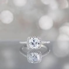 an engagement ring with a cushion cut diamond in the center