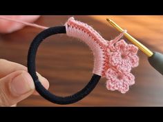 someone is crocheting a piece of fabric with a hook and yarn in the shape of a flower