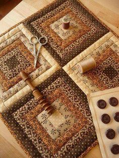 a table topped with lots of different types of quilts and sewing supplies on top of a wooden table