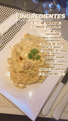 a white plate topped with pasta on top of a table