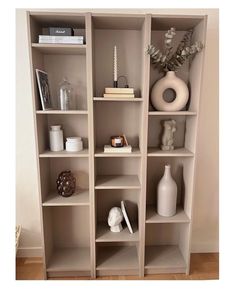 a book shelf filled with lots of books and vases on top of it's shelves