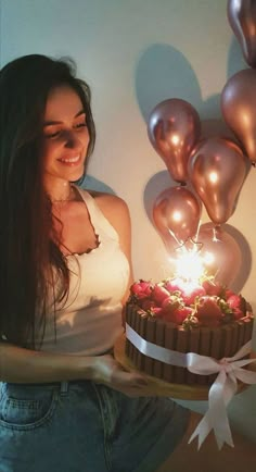 a woman holding a cake with candles in it