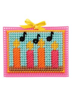 a cross stitch pattern with three candles on the front and two birds on the back