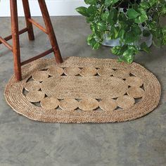 a rug on the floor next to a chair and potted plant