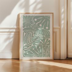 a green and white print sitting on top of a hard wood floor next to a door