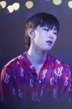 a man with ear piercings on his ears standing in front of some light circles