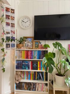 a bookshelf filled with lots of books in front of a flat screen tv