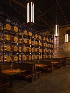 a wine cellar filled with lots of barrels and wooden tables in front of it's walls