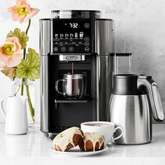 a coffee maker and some pastries on a table