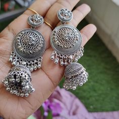 Elevate your jewelry collection with these stunning Oxidized Silver Jhumka Earrings, inspired by traditional Kashmiri craftsmanship. Handcrafted with meticulous attention to detail, these earrings feature intricate floral motifs and exquisite filigree work that perfectly captures the essence of Indian heritage. The large circular design is complemented by delicate ghungroo bells, adding a playful jingle with every movement. Ideal for festive occasions, weddings, and casual outings, these stateme Heavy Drop Earrings Jhumkas, Heavy Drop Jhumkas, Festive Nickel-free Metal Danglers, Navratri Drop Danglers, Bohemian Heavy Drop Chandelier Earrings, Dangle Metal Chandbalis With Latkans, Dangle Chandbalis With Latkans In Metal, Chandbali Bridal Earrings In Metal, Bohemian Drop Jhumkas In Metal