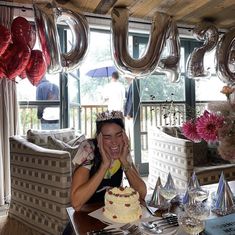 a woman sitting at a table in front of a cake