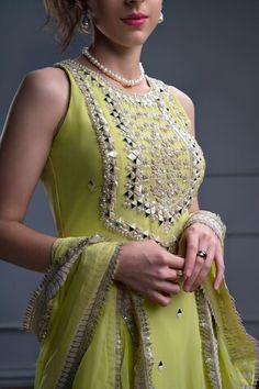 Lime green sleeveless kurta with floral bloom embroidery using mirror, pearl and resham highlights. Paired with a sharara and an embroidered border dupatta. - Aza Fashions Bollywood Style Sleeveless Embellished Anarkali Set, Festive Sleeveless Dress With Gota Work, Elegant Sleeveless Palazzo Set For Festivals, Sleeveless Party Dress With Gota Work, Sleeveless Mirror Work Anarkali Set For Festive Occasions, Pista Green Gota Work Dress, Sleeveless Anarkali Set With Mirror Work For Festive Occasions, Sleeveless Anarkali Dress With Gota Work, Elegant Pista Green Dress With Gota Work