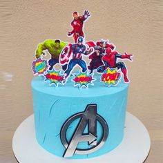 a blue cake with avengers stickers on it