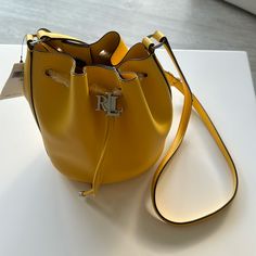 New Ralph Lauren Yellow Leather Bucket Bag Tote Purse. $175. Height: 8.5”. Width: 7.25”. Depth: 5.5”. Elegant Yellow Bag With Silver-tone Hardware, Elegant Yellow Bags With Silver-tone Hardware, Yellow Bucket Bag With Gold-tone Hardware, Classic Yellow Bag With Silver-tone Hardware, Classic Yellow Bags With Silver-tone Hardware, Yellow Rectangular Bag With Silver-tone Hardware, Luxury Yellow Bags With Silver-tone Hardware, Classic Bucket Bag With Branded Hardware, Yellow Bags With Silver-tone Hardware For Everyday Use