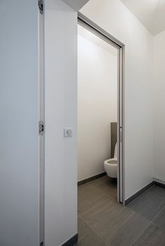 an open door leading to a toilet in a bathroom