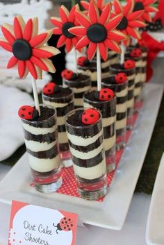 there are many desserts with red flowers in them on the table at this party