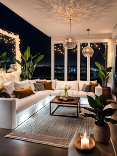 a living room filled with lots of furniture next to large windows and lights on the ceiling