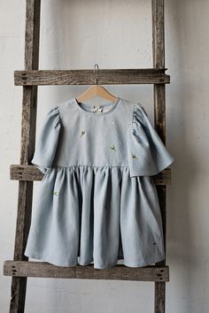 Exclusive flower dress is made of 100% soft medium weight linen.  Details: - Choose size in the drop down menu - Colour: Sky blue - Embroidered roses, rose buds & branches (front & back) - Composition: 100% Oeko-Tex certified linen - Flutter sleeves - Gathered waist  - White ribbon in the back - Medium weight linen - Linen care: machine wash gentle; tumble dry low, ironing optional - The price is for one flower dress, other pictured items are not included Blue Cotton Dress With Floral Applique, Embroidered Light Blue Cotton Dress, Light Blue Embroidered Cotton Dress, Light Blue Linen Dresses For Spring, Flower Embroidery Dress, Embroidered Roses, Dress Linen, Girls Girl, Dress Flower