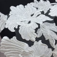 an embroidered fabric with white flowers on black and white background, closeup view from the bottom