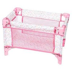 a pink and white baby crib with polka dot print on it's sides