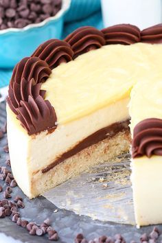 a cake with chocolate and white frosting on it sitting on a plate next to some cookies