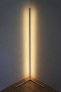 the light is shining through two poles in an empty room with wood flooring and white walls