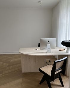 a desk with a chair and computer on it