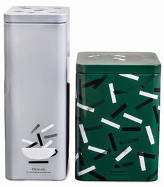 a green and white canister next to a silver box with black and white designs on it