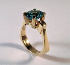 A 14kt yellow gold original designer ring Center stone is a 10x8 mm oval Swiss blue topaz Side diamonds are two round 2.5mm si1 g/h color tdw .14cts Can be ordered in white gold, yellow gold, rose gold, and platinum Comes in all sizes Comes in a beautiful box 100% MONEY BACK GUARANTEE Modern Topaz Ring With Center Stone In Yellow Gold, Modern Yellow Gold Topaz Ring With Center Stone, Modern Yellow Gold Blue Topaz Ring, Modern 14k Gold Topaz Ring With Center Stone, Modern 14k Gold Topaz Ring With Prong Setting, Modern Topaz Ring In 14k Gold With Prong Setting, Modern Topaz Ring With Accent Stones, Modern Oval Solitaire Topaz Ring, Modern Oval Topaz Ring With Prong Setting