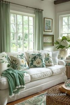 a living room filled with white furniture and green curtains