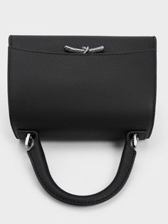 This product is made with at least 20% sustainable materials by weight. CHARLES & KEITH uses recycled, degradable, organic, and water-based materials in our eco-conscious collection. Classy, versatile and timeless, our black Huxley top-handle bag with a front flap design is made for the stylish, modern woman. This sleek and compact piece can easily be dressed up or down, while the knotted detail with crystal embellishments adds a subtle touch of shine. Equally as functional, the striking metallic accent will ensure your belongings stay safe and secure with its push-lock closure. Charles Keith, Crystal Embellishment, Eco Conscious, Sustainable Materials, Metallic Accents, Handle Bag, Stay Safe, Modern Woman, Top Handle