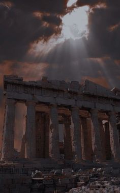 the sun shines brightly through clouds over an ancient temple with columns and pillars on it