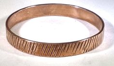 "Textured copper bangle Bangle is 8\"  in inside circumference, 2 1/2\" in diameter, 3/8\" wide, and 0.07\" thick. TO DETERMINE A BANGLE BRACELET SIZE STEP 1: Close your fingers together, bringing your thumb and little finger together (as though putting on a bangle). STEP 2: Using a strip of paper or tape measure, measure around the closed hand at the widest point, pulling the tape snug against the skin. If you are using a plain strip of paper, mark the paper with a pen, then measure the strip w Hand Forged Copper Bangle Bracelet, Handmade Copper Bangle Bracelets, Hammered Copper Bangle Bracelet, Hammered Copper Bangle Bracelets, Rose Gold Copper Cuff Bangle, Rose Gold Copper Bangle Cuff Bracelet, Hammered Rose Gold Bangle, Hammered Bronze Bangle Bracelet, Handmade Copper Bangle