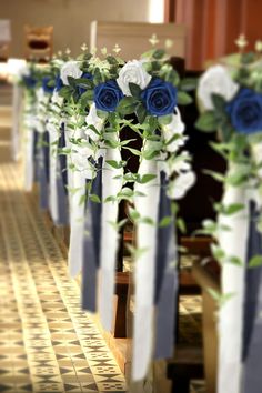 blue and white flowers are placed on the pews in this church wedding ceremony aisle