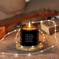 a candle that is sitting on top of a table next to a string of lights