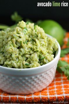 a white bowl filled with rice next to green peppers and cilantro on an orange towel