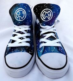 a pair of blue and white sneakers with space painted on the upper part of them