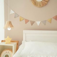 a white bed sitting under a clock above it's headboard in a bedroom