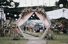 an outdoor wedding setup with white draping and flowers