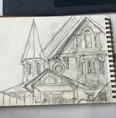 a pencil drawing of a house on top of a desk next to a laptop computer