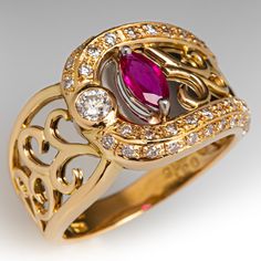 This fantastic 18K yellow gold ring features a pierced design filled with scroll details that are backed with curved platinum backgrounds. The ring is accented with one (1) prong set marquise cut natural ruby, one (1) bezel set round brilliant cut diamond, and forty-six (46) bead set round brilliant cut diamonds. The ring measures 12.3mm at the top, rises 4.4mm above the finger, tapering to 2.9mm wide and 0.8mm thick at the base of the shank. "0.31 D038 Pt900 18K is stamped on the inside shank. It is currently a size 5.75. Luxury Marquise Ruby Ring, Elegant Marquise Ring With Intricate Design, Elegant Yellow Gold Ruby Ring With Intricate Design, Elegant Marquise Ruby Ring With Diamond Cut, Elegant Marquise Hallmarked Rings, Luxury Ruby Marquise Cut Ring For Formal Occasions, Luxury Ruby Ring Marquise Cut For Formal Events, Elegant Marquise Gold Ruby Ring, Luxury Marquise Cut Ruby Ring For Formal Occasions